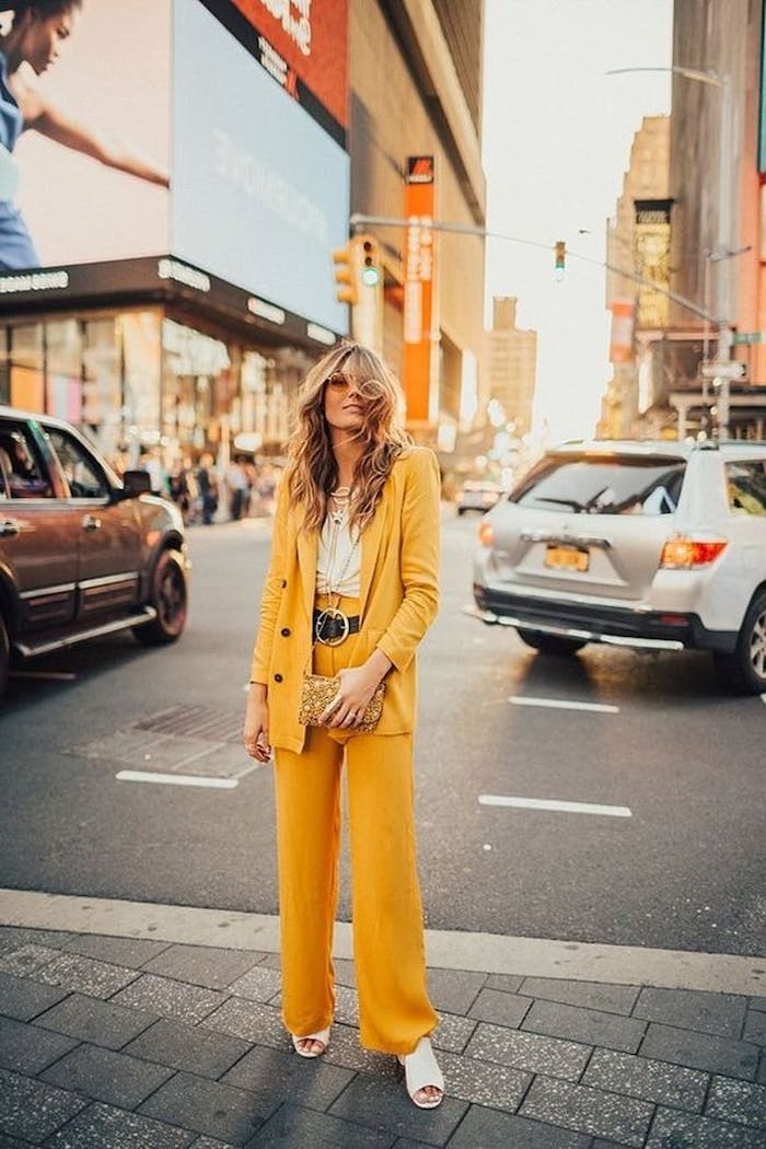 ensemble costume femme en jaune couleur pantone 2021 avec un ceinture au grand bouclier et des sandales blanc une femme dans un)grand boulevard
