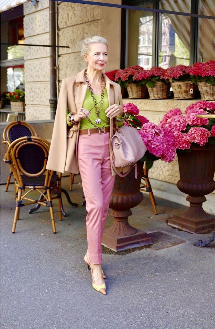 pantalon rose chemise verte manteau beige sac à main rose collier original look coloré femme 60 ans