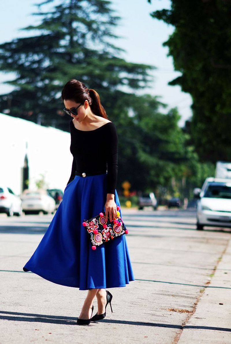 style romantique jupe midi en bleu top et chaussures noirs pochette comme accent